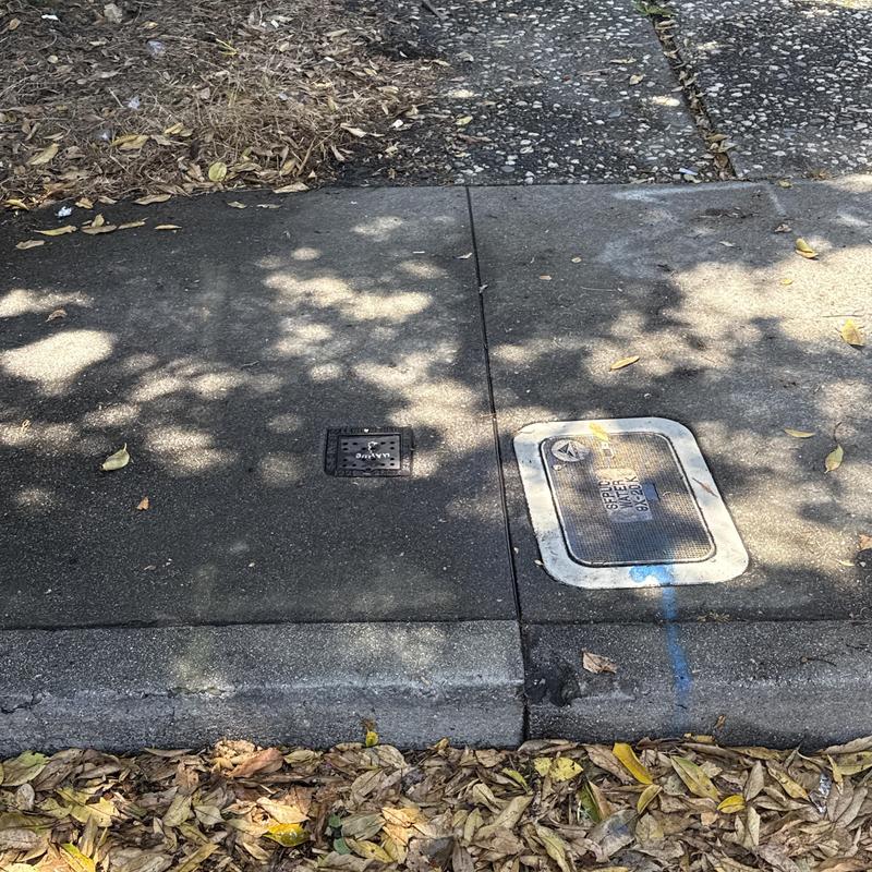 Sewer cleanout access covers on residential sidewalk