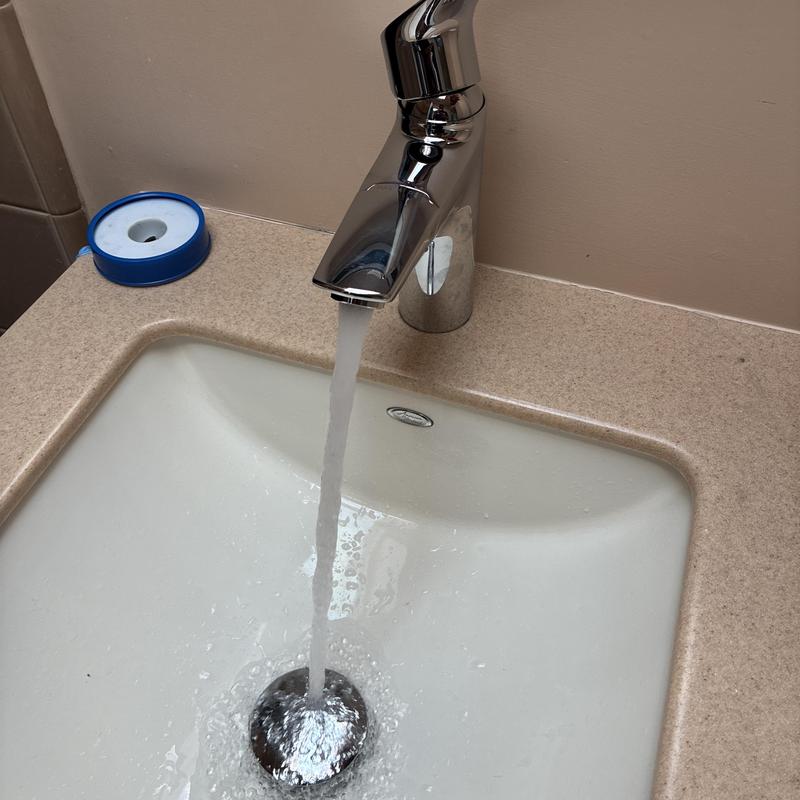 Moen basin faucet with running water in bathroom sink