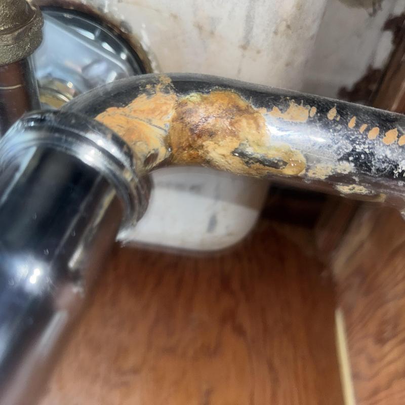 Kitchen sink waste arm with corrosion and leak damage