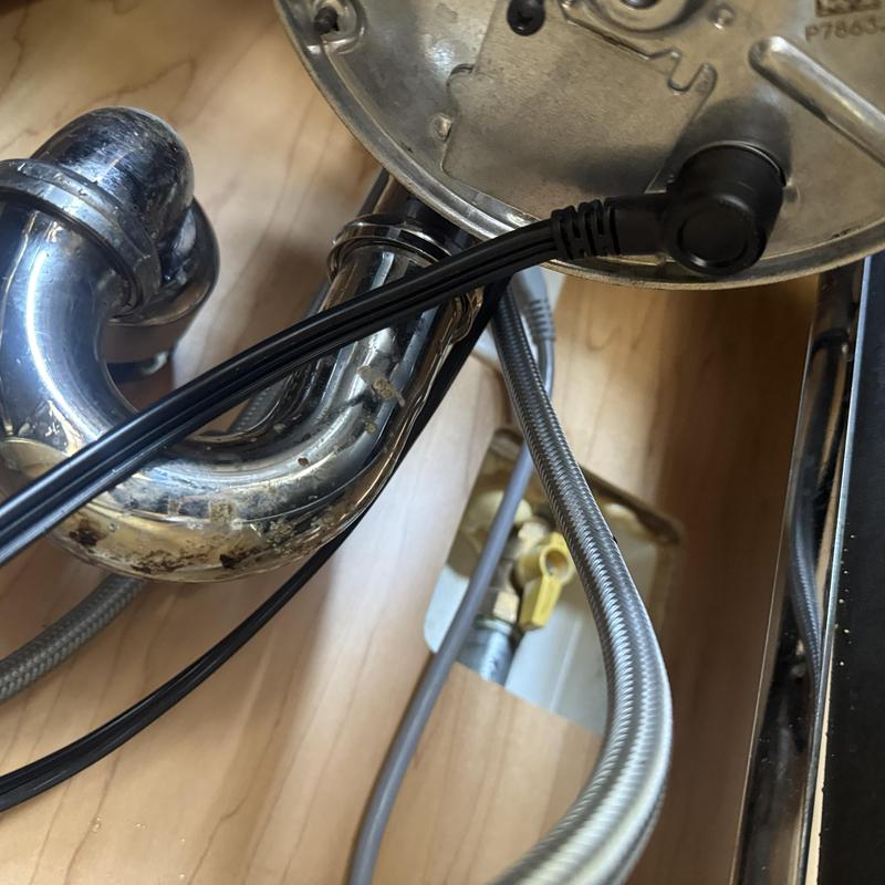 Garbage disposal wiring and drain pipes under sink