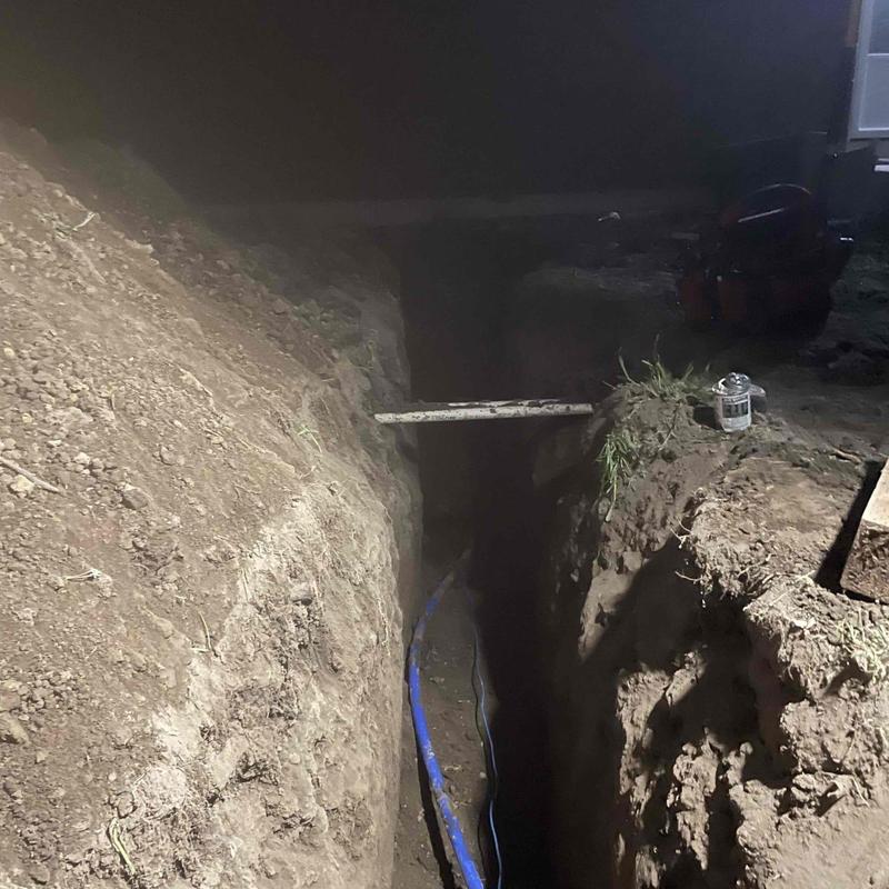 Main water line trench with blue pipe installation Main water line trench with blue pipe installation