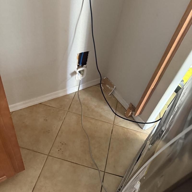 Ice maker valve access hole with wiring near fridge