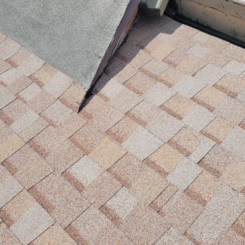 Asphalt shingle roof section near flashing installation Asphalt shingle roof section near flashing installation
