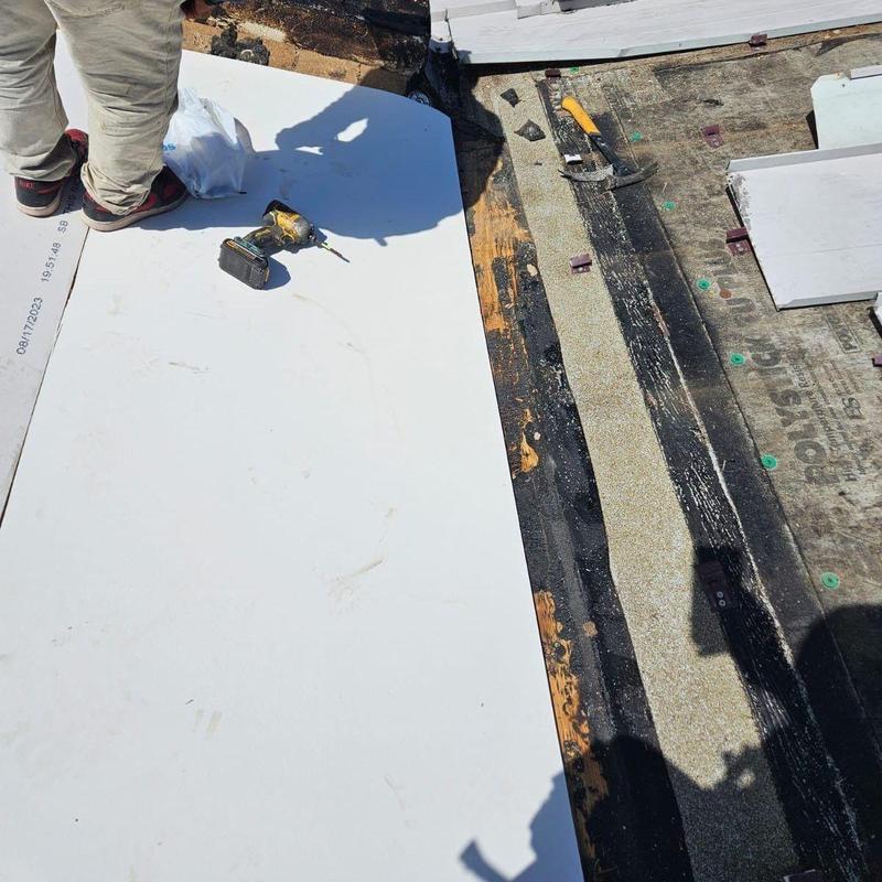 Flat roof base sheet installation with tools and worker Flat roof base sheet installation with tools and worker