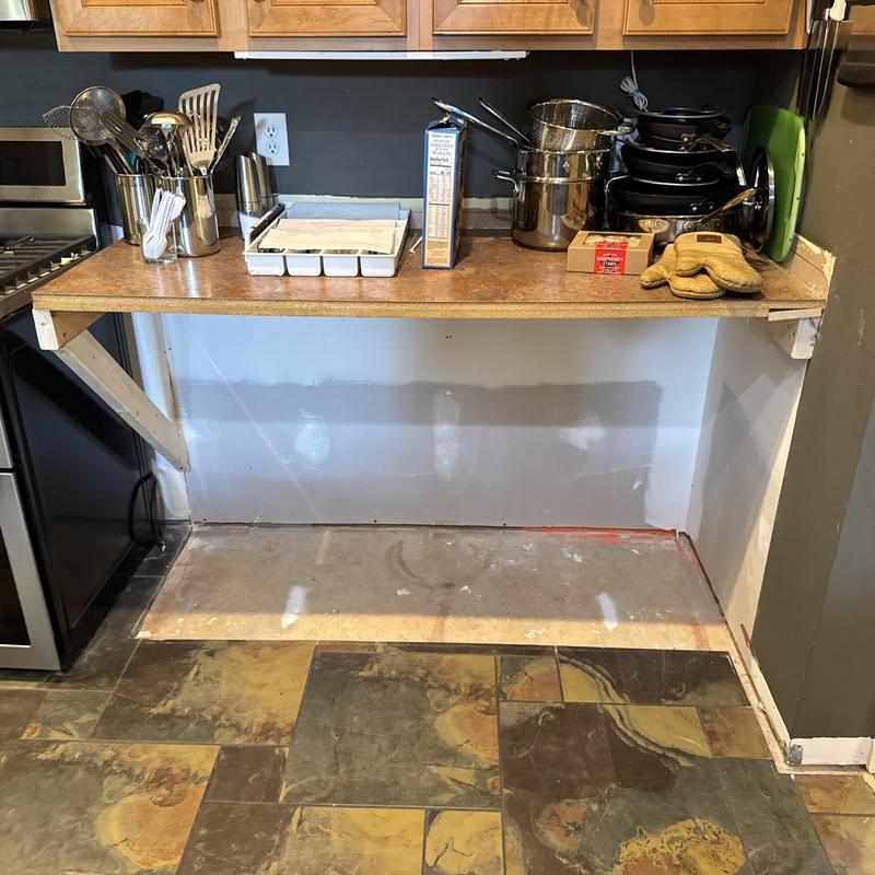 Drywall patch and prep beneath countertop in kitchen