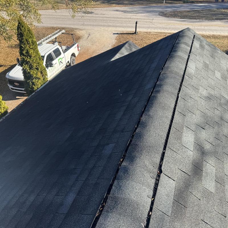 Asphalt shingle roof close-up with ridge vent inspection
