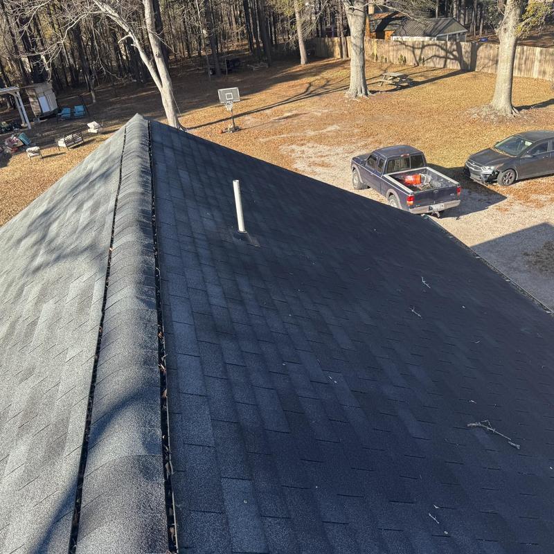 Asphalt shingle roof with vent pipe and ridge cap