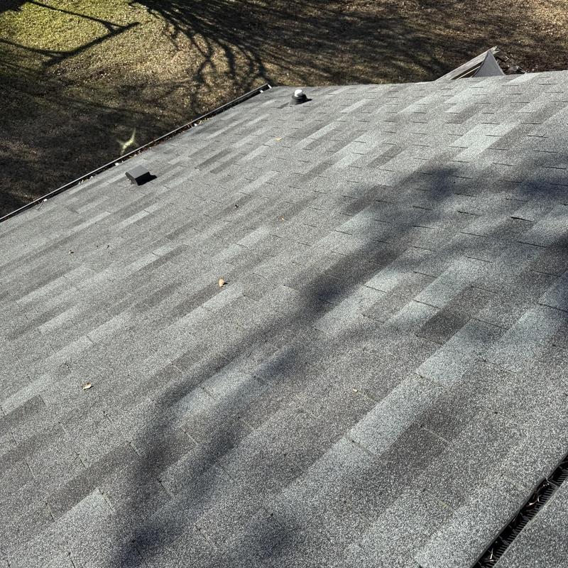 Asphalt shingle roof with vent pipes and shadows