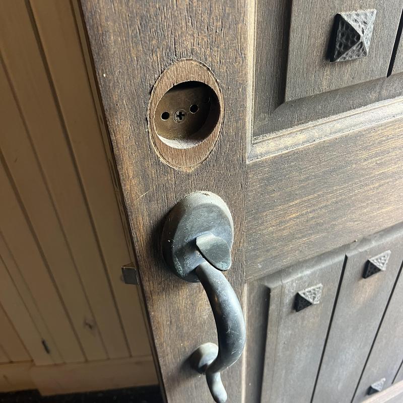 Deadbolt lock hole on wooden door with handle removed