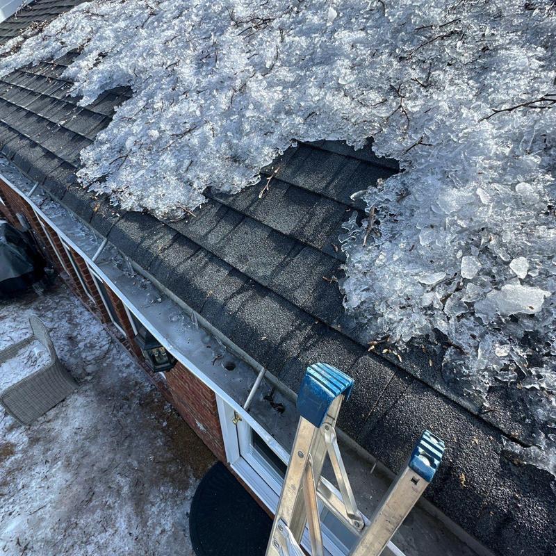 Asphalt shingle roof with ice accumulation and ladder