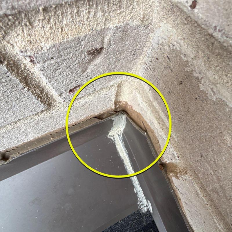 Metal flashing corner with sealant gap and wall damage