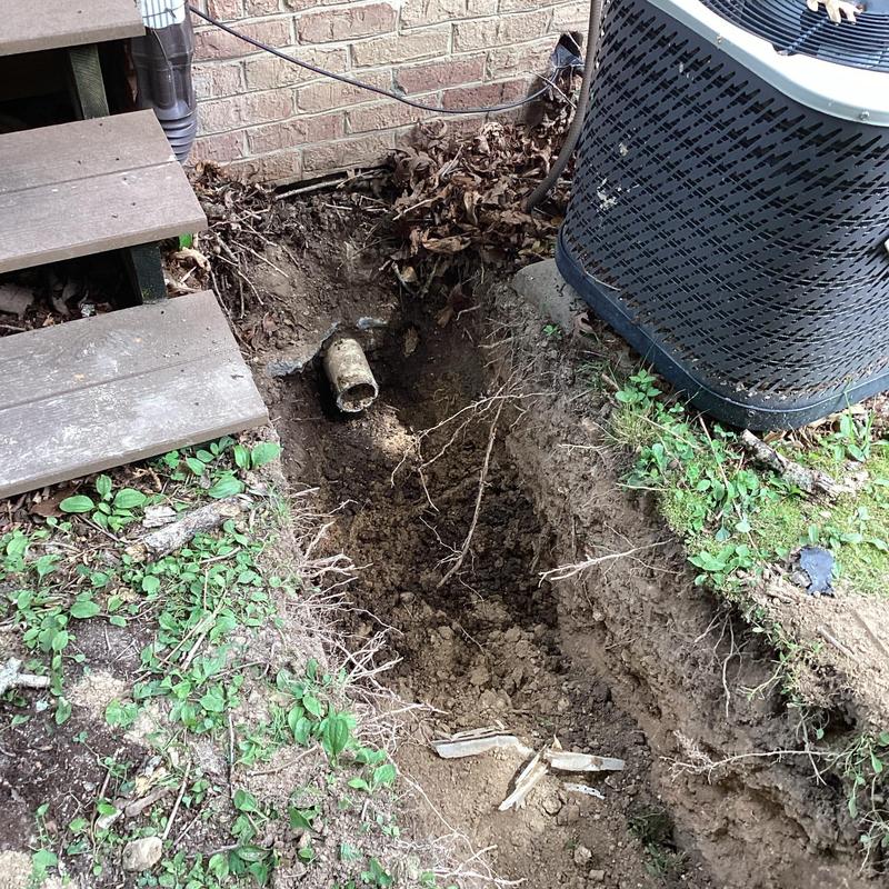 4-inch PVC sewer line excavation beside house and AC unit
