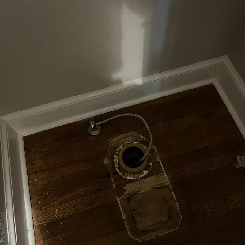 Toilet flange and supply line on hardwood floor installation site