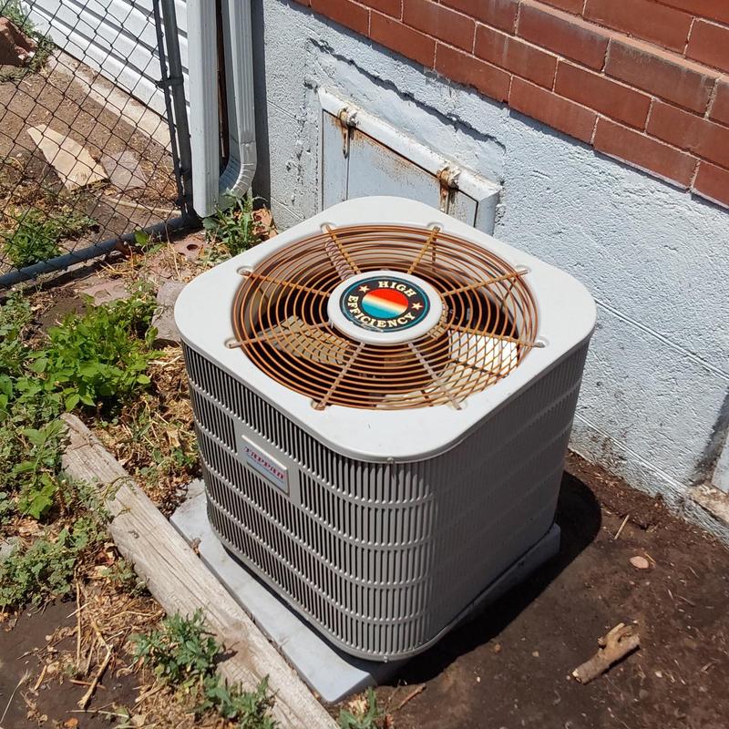 Air conditioner unit with rusted fan grate outdoors
