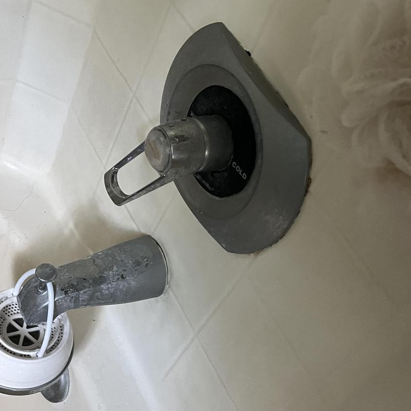 Bathtub faucet and cold water handle on tiled wall