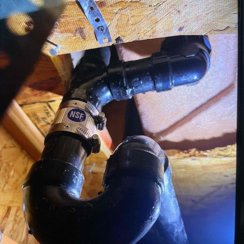ABS plumbing pipe with metal clamp in ceiling space