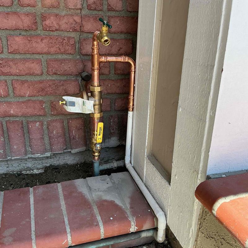 Copper hose bib and pressure regulator installation on wall