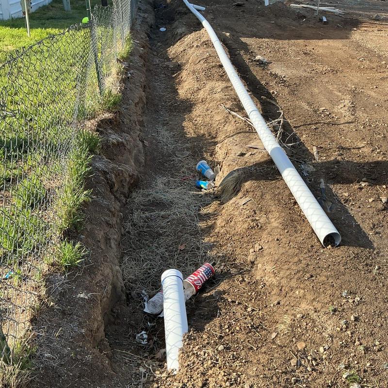 Septic drain field trench with PVC pipe and debris Septic drain field trench with PVC pipe and debris