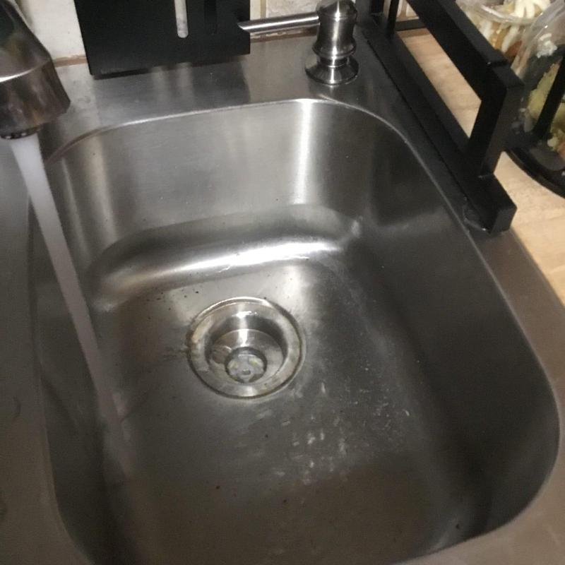 Kitchen sink with running water and drain visible Kitchen sink with running water and drain visible