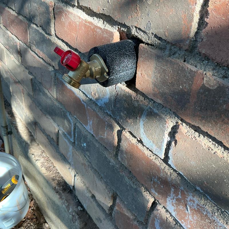 Hose bib quarter turn valve installed on brick wall