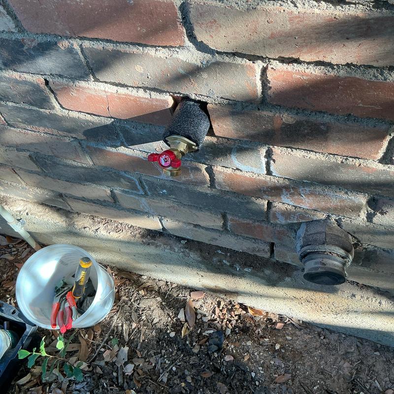 Hose bib with quarter-turn valve installed in brick wall