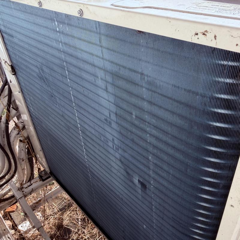 Mini-split outdoor condenser coil with dirt buildup Mini-split outdoor condenser coil with dirt buildup