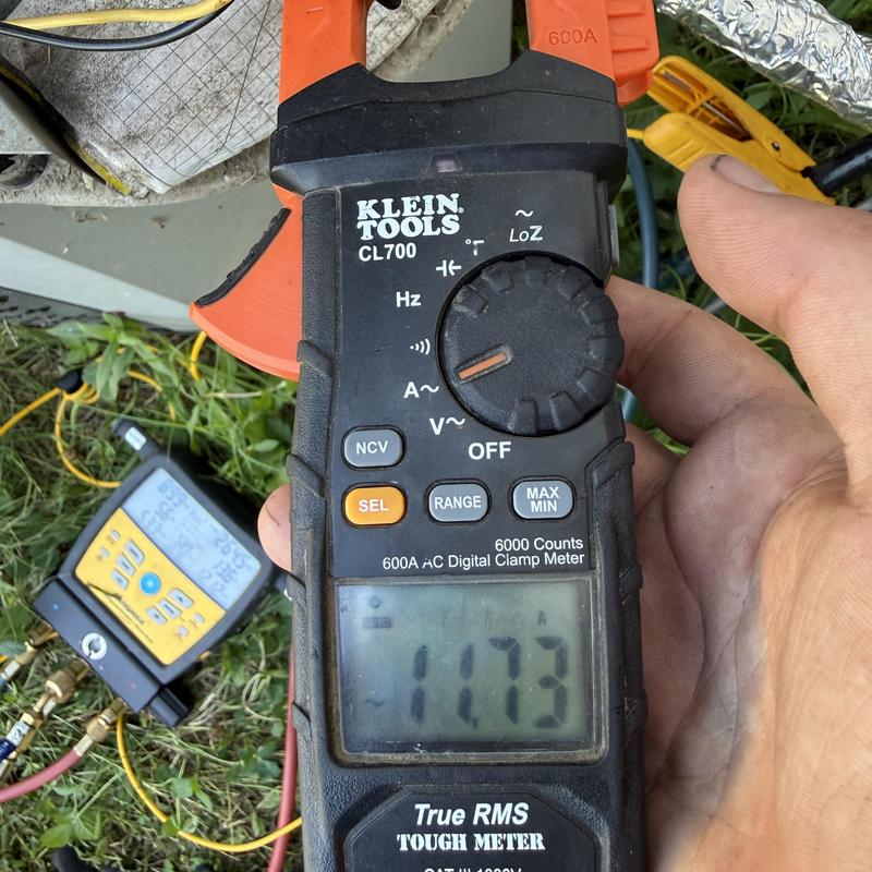 Clamp meter measuring HVAC electrical current outdoors Clamp meter measuring HVAC electrical current outdoors