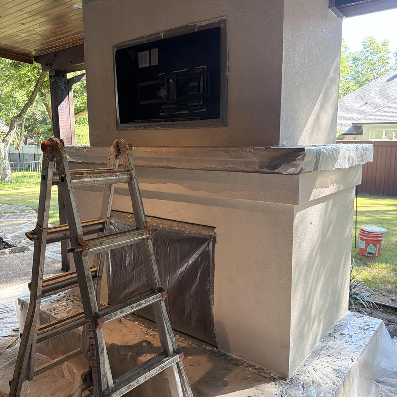 Stucco chimney with covered fireplace and TV mount
