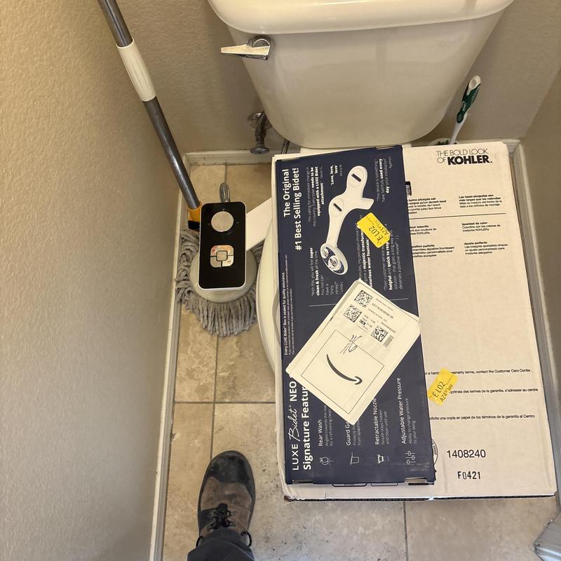 Bidet seat box on toilet in bathroom corner