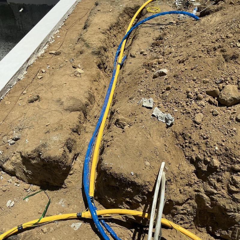 PE gas line trench with yellow and blue conduit cables