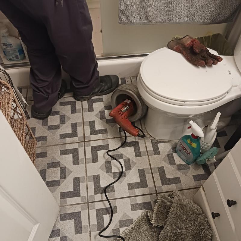 Toilet drain snaking with electric auger and gloves