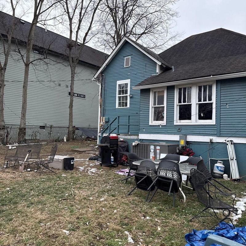 Residential roofing shingles with hail damage on blue house