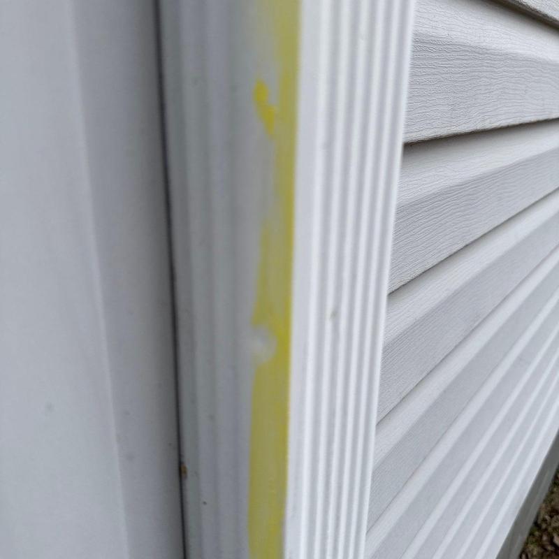 Vinyl siding corner trim with yellow sealant applied