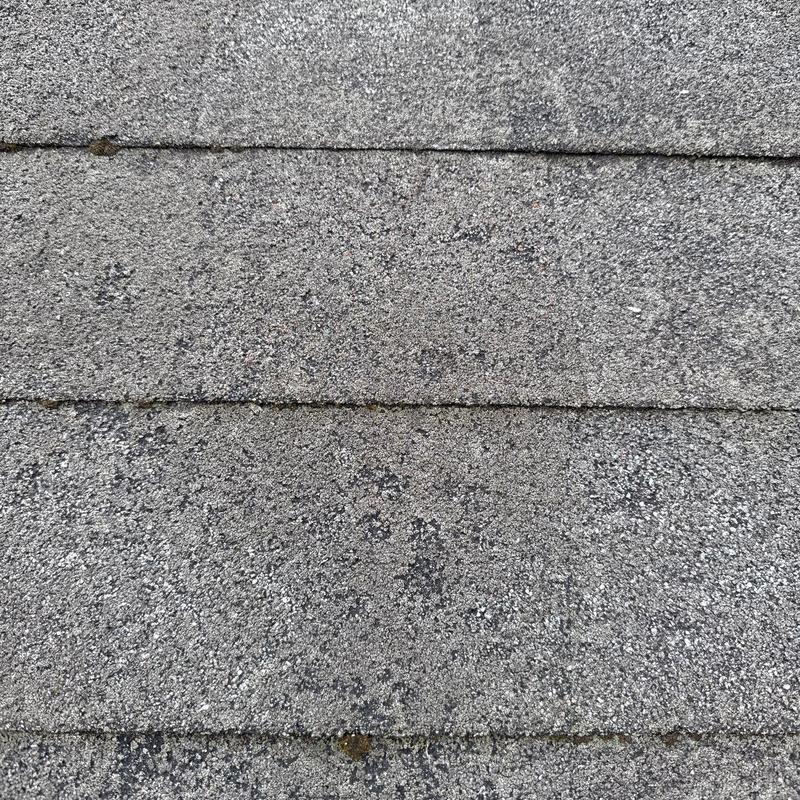 Asphalt roof shingles with visible hail damage close-up