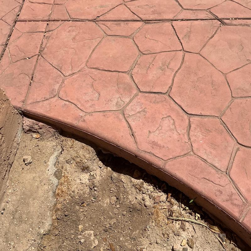 Stamped concrete edge with exposed soil and dirt gap