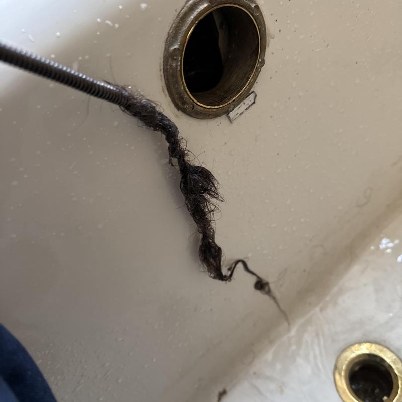 Shower drain clogged with hair during snaking service