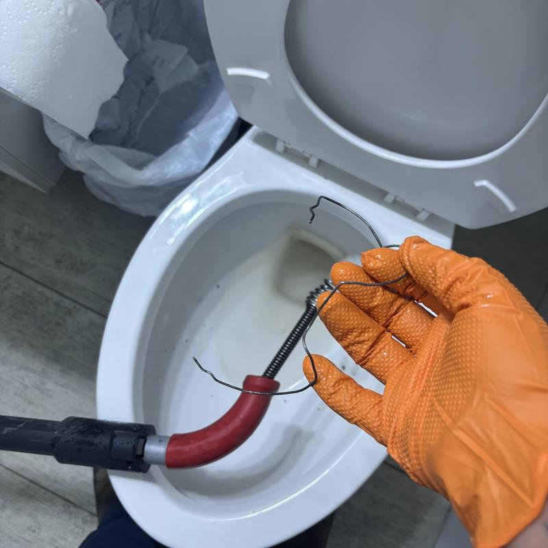 Toilet drain clog wire removal with plumbing snake Toilet drain clog wire removal with plumbing snake