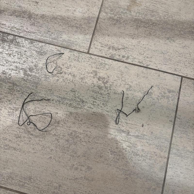 Toilet clog wire debris on tile floor after removal Toilet clog wire debris on tile floor after removal