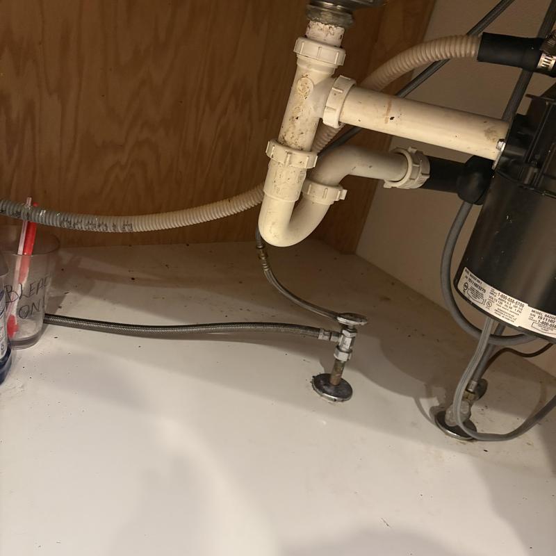 Kitchen sink drain pipes and garbage disposal connections under cabinet Kitchen sink drain pipes and garbage disposal connections under cabinet