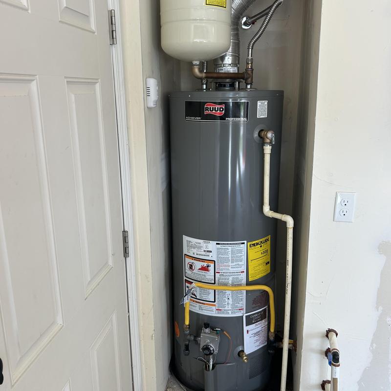Water heater with pipe connections in utility closet Water heater with pipe connections in utility closet
