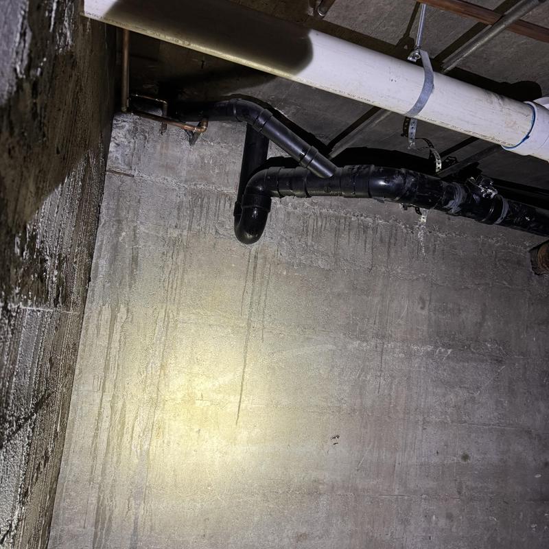 Sewer drain pipe in basement with water damage marks Sewer drain pipe in basement with water damage marks