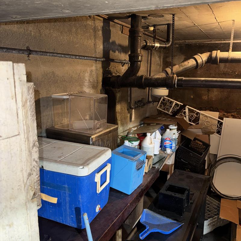 Sewer drain pipes and basement utility area with clutter Sewer drain pipes and basement utility area with clutter