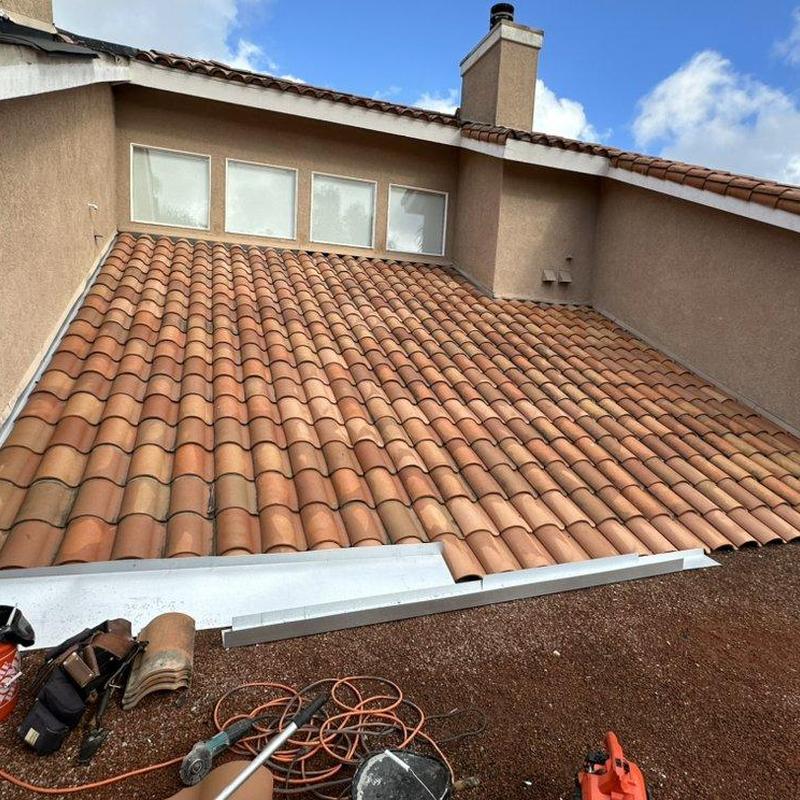 Tile roof inspection with tools on flat roof edge Tile roof inspection with tools on flat roof edge