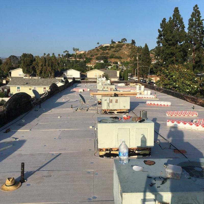 Commercial flat roof with HVAC units and insulation rolls Commercial flat roof with HVAC units and insulation rolls