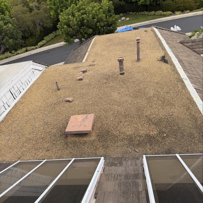 Gravel flat roof with vent pipes and skylights Gravel flat roof with vent pipes and skylights