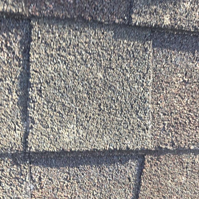 Asphalt shingle roof with hail impact damage close-up
