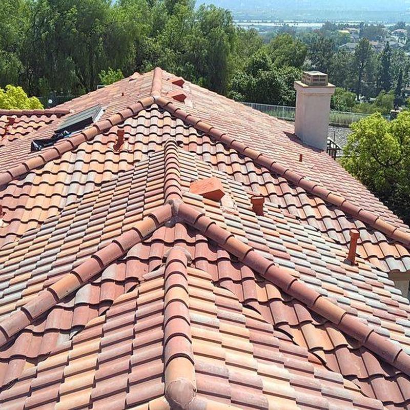 Tile roof ridge and vent pipes with chimney nearby Tile roof ridge and vent pipes with chimney nearby
