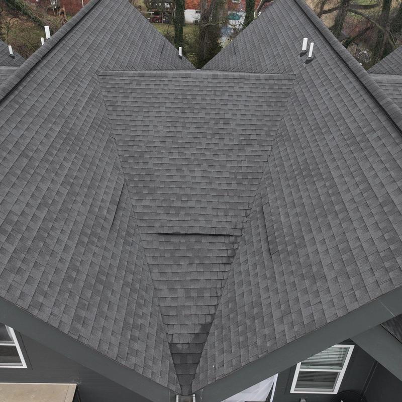Asphalt shingle roof valley with visible wear and damage