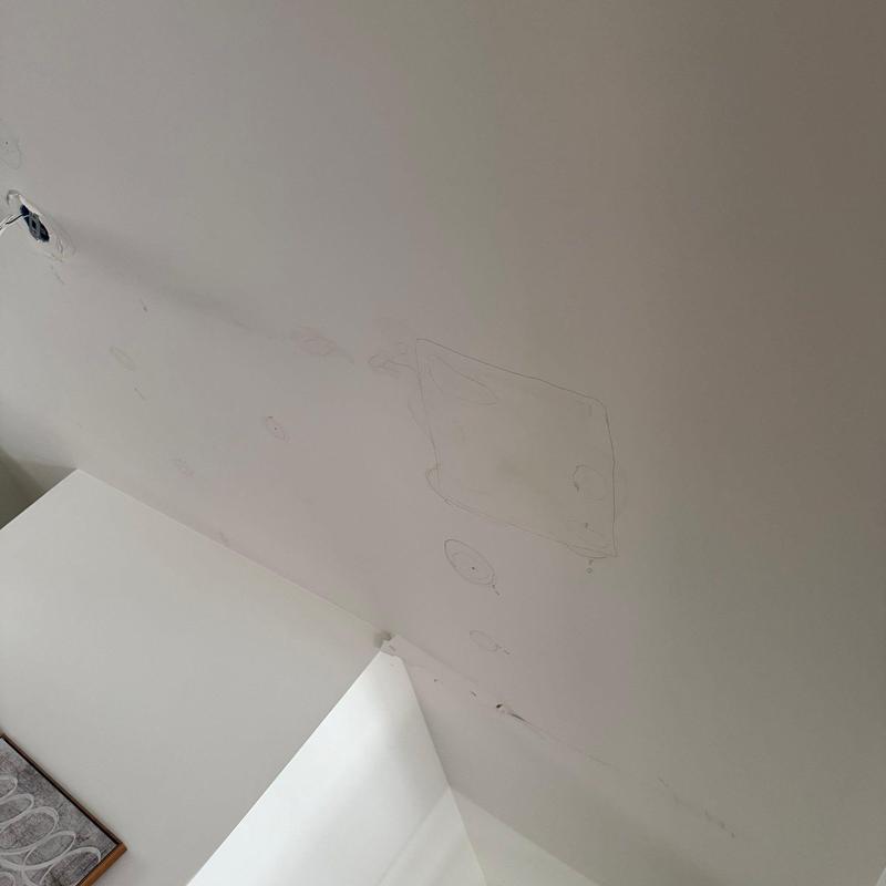 Drywall ceiling with water damage stains and markings