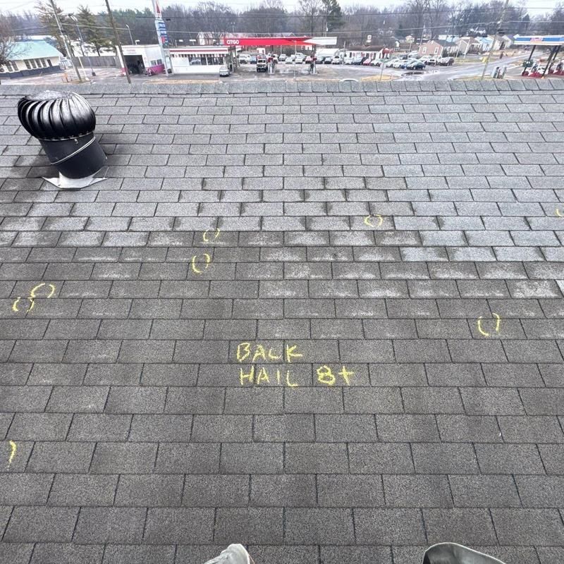 Roof shingles with hail damage markings and vent turbine